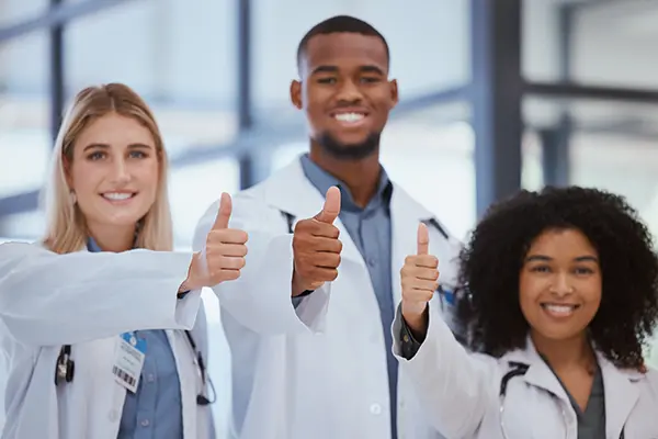 Smiling doctors with thumbs up